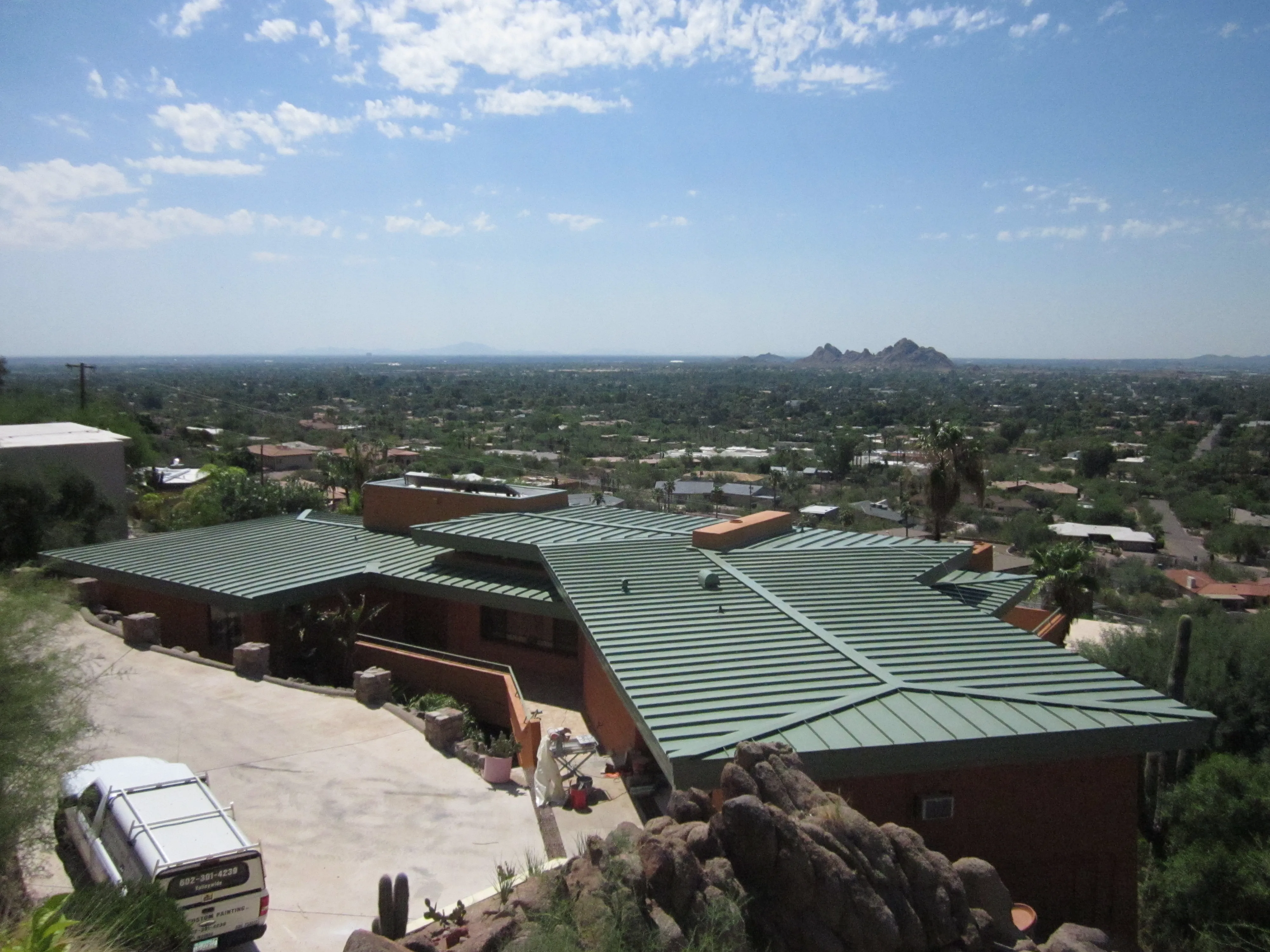 An overhead view of an Arizona home with a green standing seam metal roof.