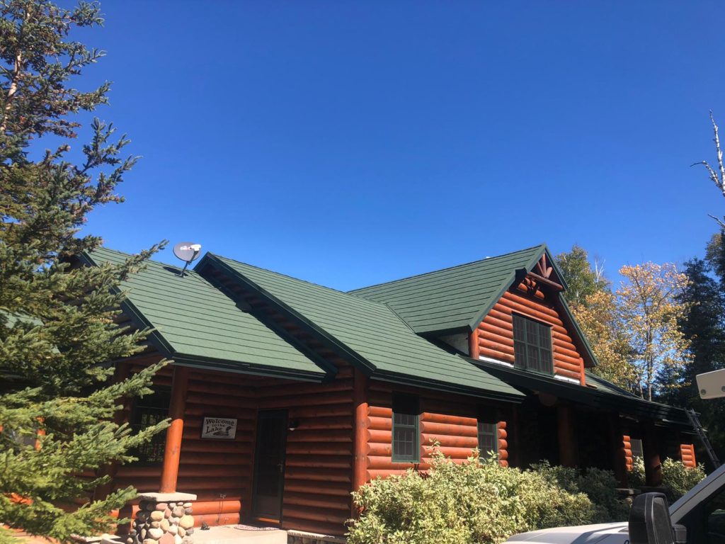 A new green metal roof on a log home.