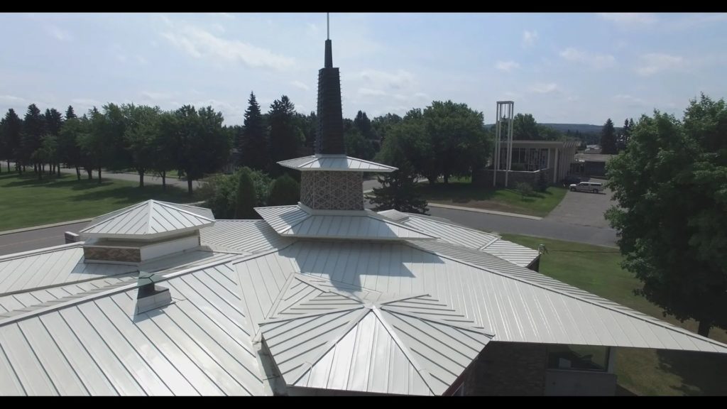 a complicated church roof with natural metal roofing.