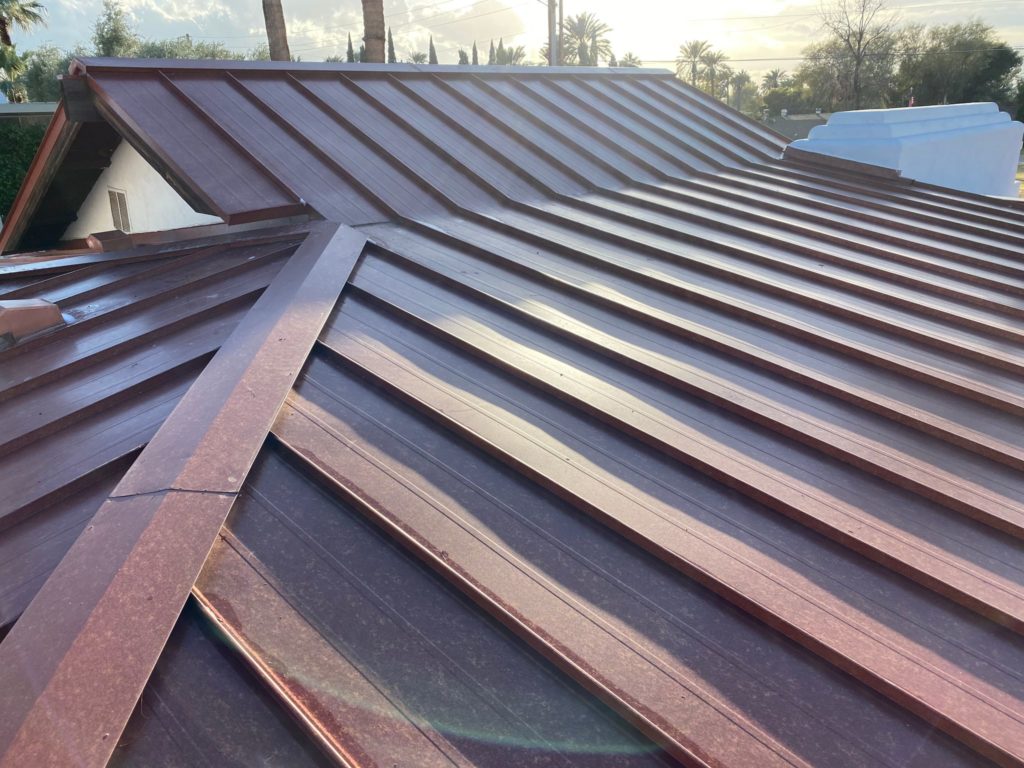 A brick red standing seam metal roof on a house.