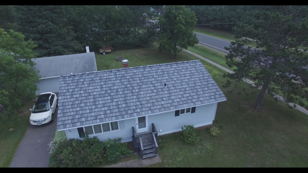 a metal slate roof on a small gray house from above.
