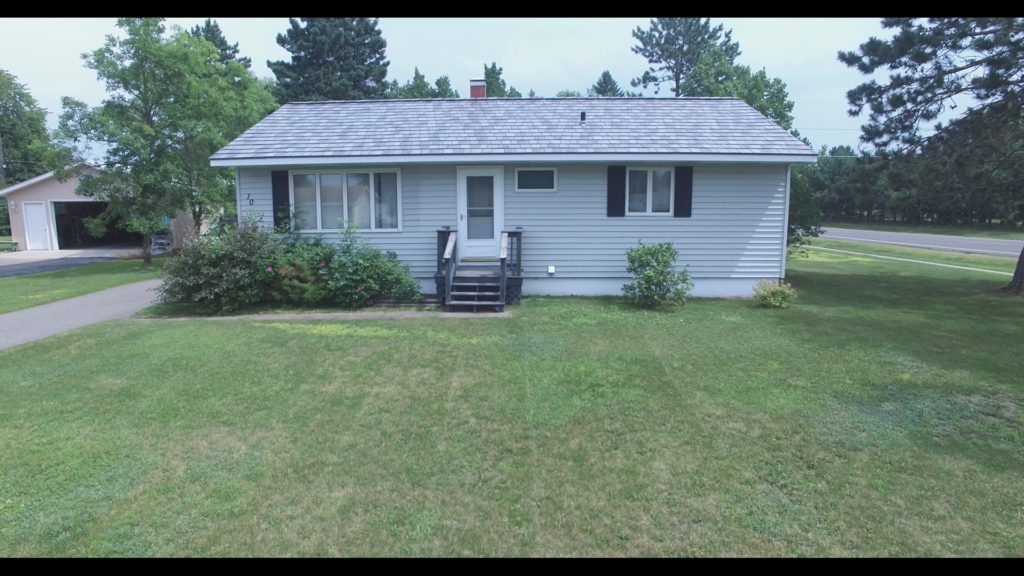 a metal slate roof on a small gray house.