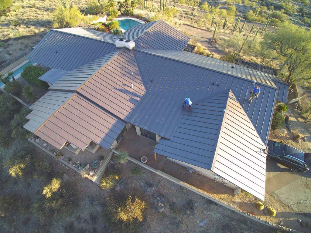 Overhead view of a home with a brown standing seam metal roof.