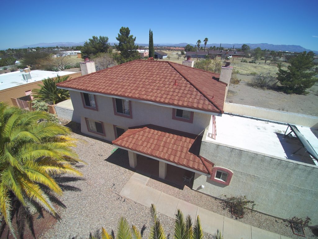 An overhead view of an Arizona home with a new red stone coated steel metal roof installed by vertex roofing.