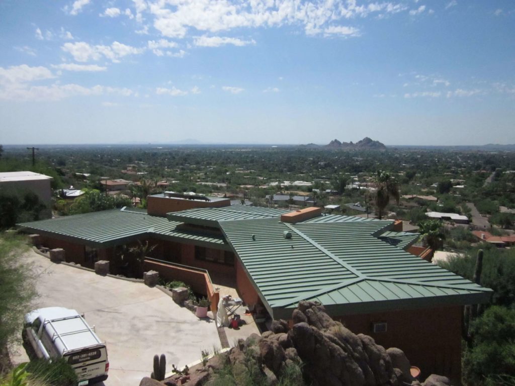 A green low slope standing seam metal roof on a home in Arizona.