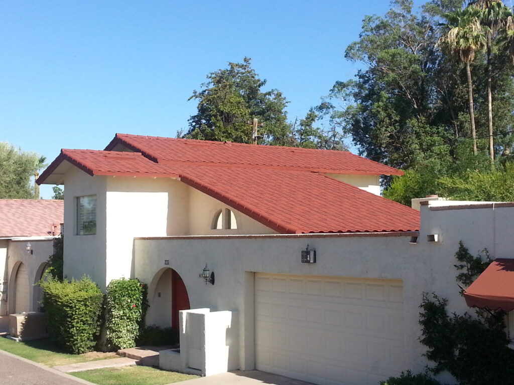 A spanish style home with a new red stone coated steel metal roof.